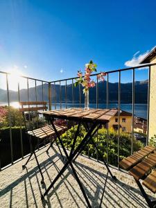 einen Tisch mit einer Blumenvase auf dem Balkon in der Unterkunft Casa Caterina in Lezzeno