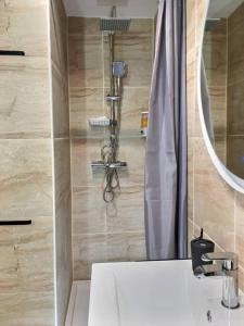 een badkamer met een wastafel en een douche met een spiegel bij Bleu Lavande - Coquet appartement ambiance village in Istres