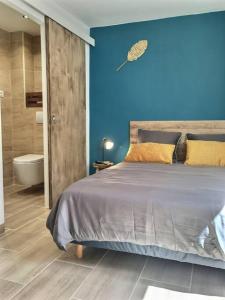 een slaapkamer met een bed en een blauwe muur bij Bleu Lavande - Coquet appartement ambiance village in Istres
