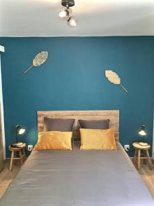 een blauwe slaapkamer met een bed met 2 kussens bij Bleu Lavande - Coquet appartement ambiance village in Istres