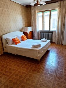 1 dormitorio con 1 cama grande con almohadas de color naranja en Locazione Turistica en Tessera