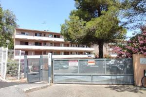 a fence with a gate in front of a building at MICHELET Studio climatisé avec balcon et parking ferme in Montpellier