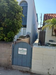 a blue gate with a sign on it in front of a building at SHARED TOWNHOUSE in MISSION BEACH in San Diego