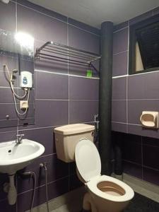 a bathroom with a toilet and a sink at Cozy Private Family Room in Bayan Lepas in Bayan Lepas