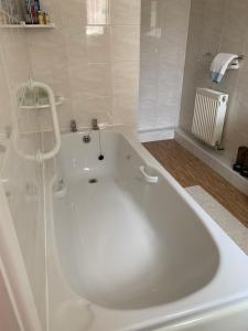 Acorn Cottage في أوليرتون: حوض استحمام كبير أبيض في الحمام