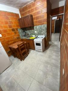 a small kitchen with a stove and a table at Departamento temporario ROSARIO in Formosa