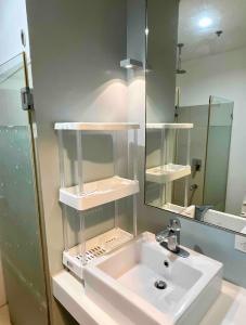 ein Badezimmer mit einem weißen Waschbecken und einem Spiegel in der Unterkunft Pico de Loro Miranda Family Beach Condo max 6 pax with fiber internet in Nasugbu