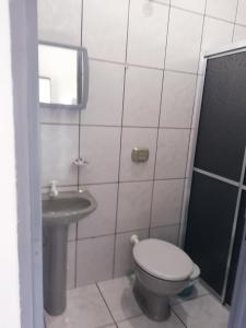 a small bathroom with a toilet and a sink at quarto para Rapaz, centro, Sinop MT in Sinop