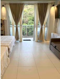 a bedroom with a bed and a large window at Pico de Loro Miranda Family Beach Condo max 6 pax with fiber internet in Nasugbu