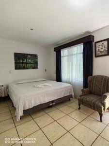 um quarto com uma cama, um sofá e uma janela em Casa Mariana em Alajuela
