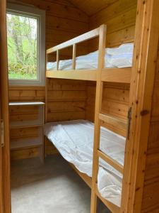 1 dormitorio con literas en una cabaña de madera en Camping Sérendipité, en Neuvéglise