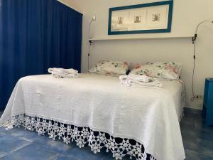 a bed with a white bedspread and pillows on it at Dammuso Tuffo nel mare in Pantelleria