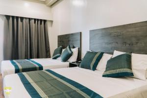 two beds in a hotel room with two beds at El Palacio Hotel & Resort in Cavite +52 photos