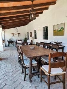 una sala da pranzo con tavolo e sedie in legno di Casa de campo - Cortijo El Palomar a Alcántara