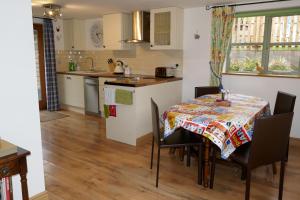 a kitchen and dining room with a table and chairs at The Old Stables @ Linden Cottage in Goring