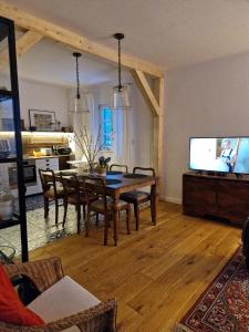 a living room with a dining room table and a tv at Kolbergarden in Olsztyn