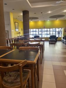 Un restaurante con mesas y sillas en una habitación. en Hotel Alcazar, en Buenos Aires