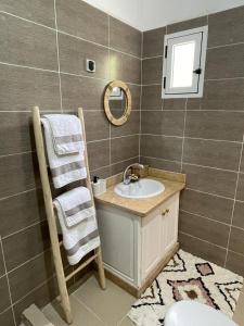 y baño con lavabo y espejo. en Maison d Hôte Ighrem en Goulmima