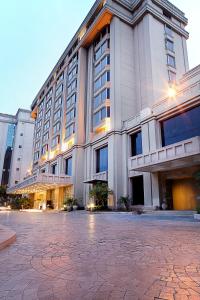 un gran edificio con un patio delante de él en The Metropolitan Hotel & Spa New Delhi, en Nueva Delhi