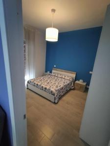 a bedroom with a bed in a blue wall at La casa di Lelè in Termoli