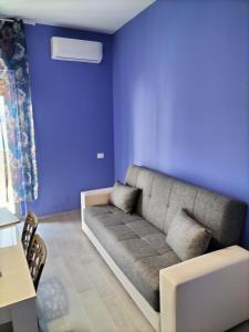 a living room with a couch against a blue wall at La casa di Lelè in Termoli