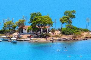 een huis op een klein eiland in het water bij Aquaterra Askeli Poros in Poros