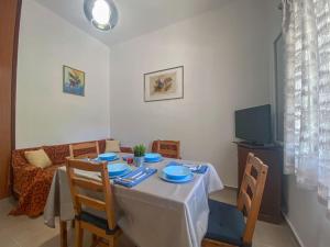 a dining room table with two chairs and a television at Aquaterra Askeli Poros in Poros