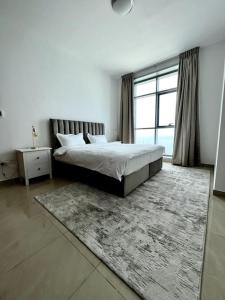 a bedroom with a bed and a large window at Luxury full sea view flat in Ajman 