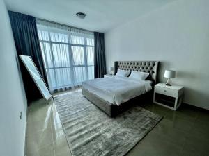 a bedroom with a bed and a large window at Luxury full sea view flat in Ajman 