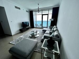 Luxury full sea view flat في عجمان: غرفة معيشة مع أريكة وطاولة