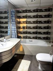 a bathroom with a sink and a tub and a toilet at Luxury full sea view flat in Ajman 