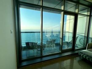 a room with a balcony with a view of the water at Luxury full sea view flat in Ajman 