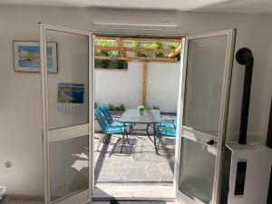 una porta di vetro che conduce a un patio con tavolo e sedie di Villa Portoferraio a Portoferraio