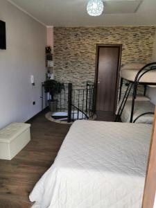 een slaapkamer met 2 stapelbedden en een bakstenen muur bij Casa Vacanza "A Due Passi" in Paravati