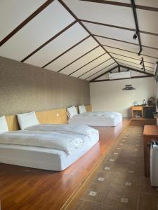 - 2 lits dans une chambre dotée de parquet et de plafonds en bois dans l'établissement Jiang's B&B 江院子庭園民宿, à Jian