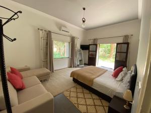 a bedroom with a bed and a couch at Maison d Hôte Ighrem in Goulmima