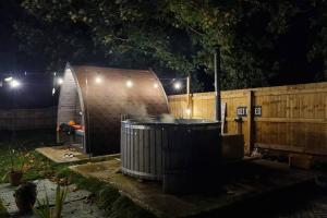 a hot tub in a backyard at night at Luna Tent Secret garden Glamping 