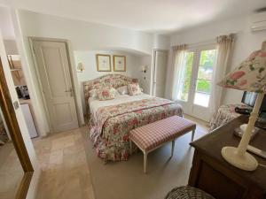 1 dormitorio con 1 cama, 1 silla y ventanas en Villa Milefleure en Grimaud