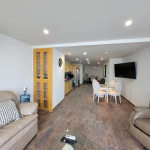sala de estar con sofá y mesa en Oceanfront Condominiums with Private Beach Access en Tijuana
