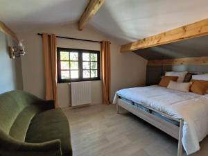 ein Schlafzimmer mit einem großen Bett und einem grünen Stuhl in der Unterkunft Villa Yéyéyette spacieuse 6 à 8 personnes in Andernos-les-Bains