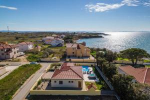 an aerial view of a house and the water at Villa Mattina, with heated pool and jacuzzi in Privlaka