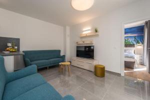 ein Wohnzimmer mit 2 blauen Sofas und ein Schlafzimmer in der Unterkunft Villa Mattina, with heated pool and jacuzzi in Privlaka