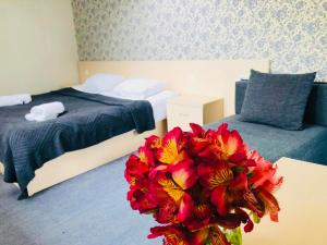 a bedroom with two beds and a vase of flowers at Guest House Vanda in Mestia