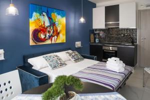 a blue room with a bed and a kitchen at Boutique Hotel Ferrara in Ferrara