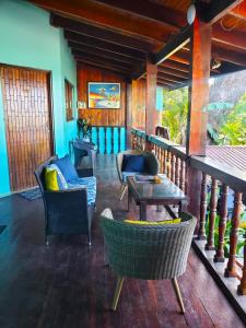 un porche con sillas y una mesa en el balcón en Hotel Villa Amarilla, en Tamarindo