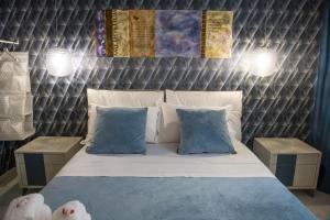 a bedroom with a bed with blue and white pillows at Boutique Hotel Ferrara in Ferrara