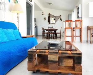 a living room with a blue couch and a coffee table at Maison Marie in Cala Gonone