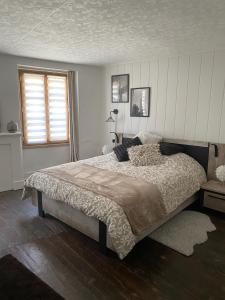 Un dormitorio con una cama grande y una ventana en POPPY appartement de charme à 2 min centre-ville, en Figeac