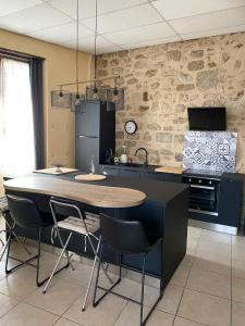 kuchnia ze stołem i krzesłami w pokoju w obiekcie POPPY appartement de charme à 2 min centre-ville w mieście Figeac