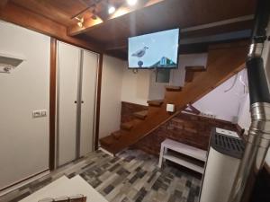 sala de estar con TV y escalera en Studio La Casita, en Gijón